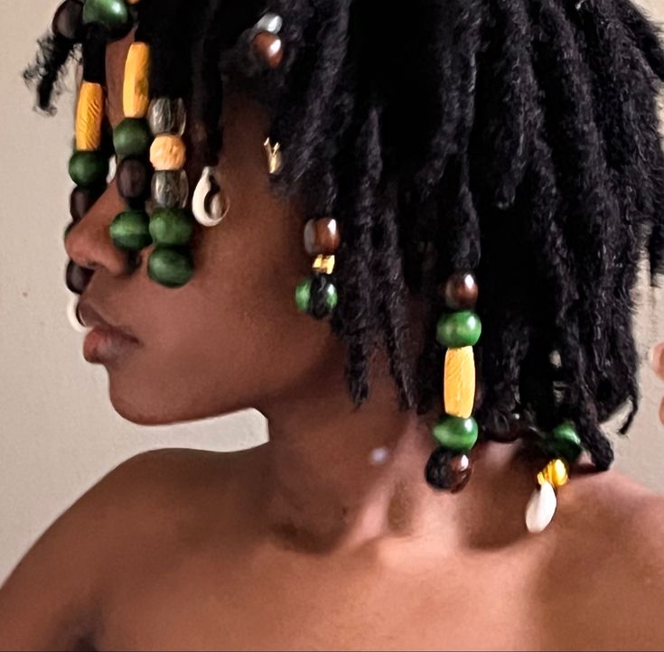 a girl with locs is wearing beads in her hair Hair Loc Jewelry, Dread Jewelry Locs, 70s Loc Styles, Bantu Knots Locs Hairstyles, Cornrows On Locs, Diy Loc Styles, Locs With Accessories, Loc Jewelry Hairstyles, Very Short Locs Hairstyles