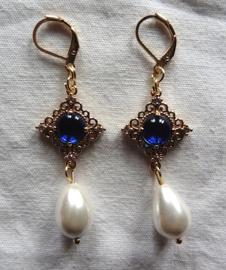 Pair of Queen earrings with blue glass Renaissance pendants. Possibility of replacing the "sleepers" hooks loops (1)  with French style hooks (2) on simple request when ordering. --------------------------- Dangling earrings with "sleepers" hooks loops (no1 on the picture) in golden stainless steel.  Possibility of replacing those "sleepers" hooks loops with French style hooks (no2) on simple request. Renaissance square pendants in golden Brass underlined by four small white zirconium oxides at Prince Kaeya, Medieval Earrings, Tudor Queen, Queen Earrings, Blue Queen, Victorian Earrings, Funky Jewelry, Square Pendant, Pearl Shell