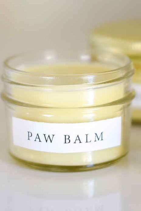 a jar of paw balm sitting on top of a white table next to another jar