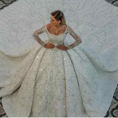 a woman in a white wedding dress standing next to a large piece of fabric with sequins on it