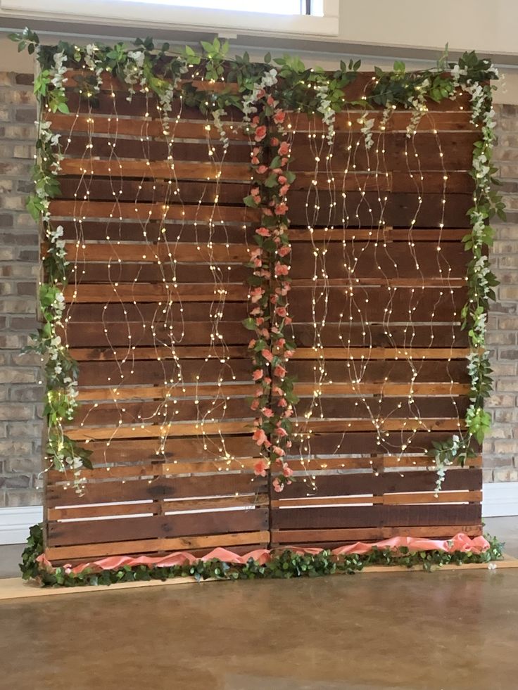 a large wooden screen decorated with greenery and lights