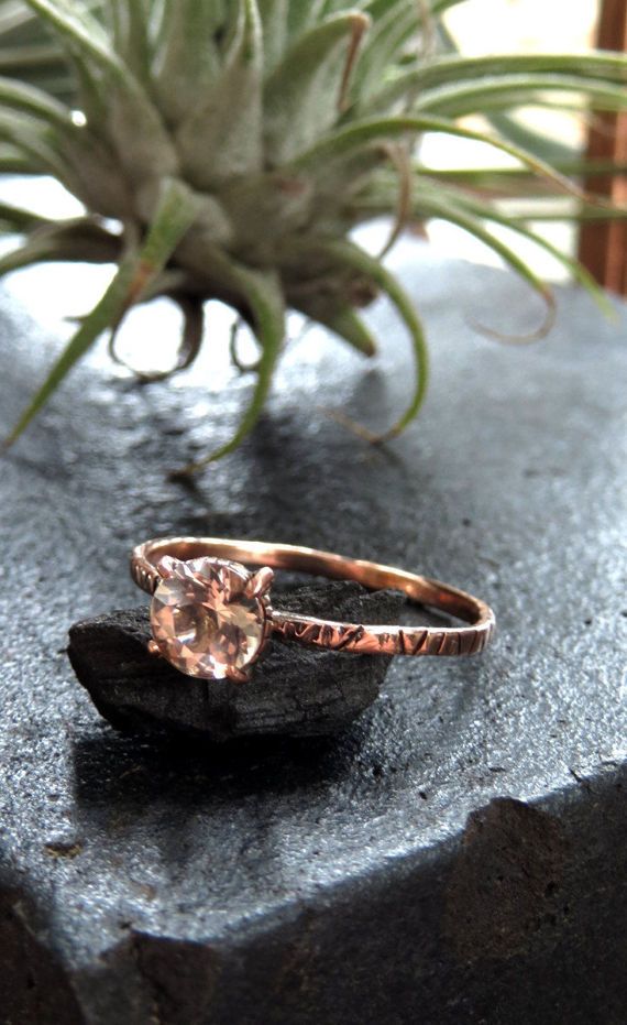 an engagement ring sitting on top of a rock next to a succulent plant