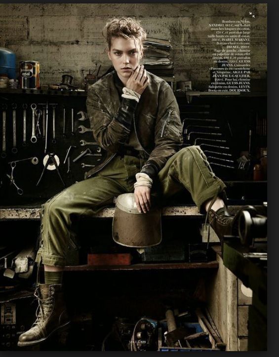 a young man sitting on top of a table next to a metal pot and wrench