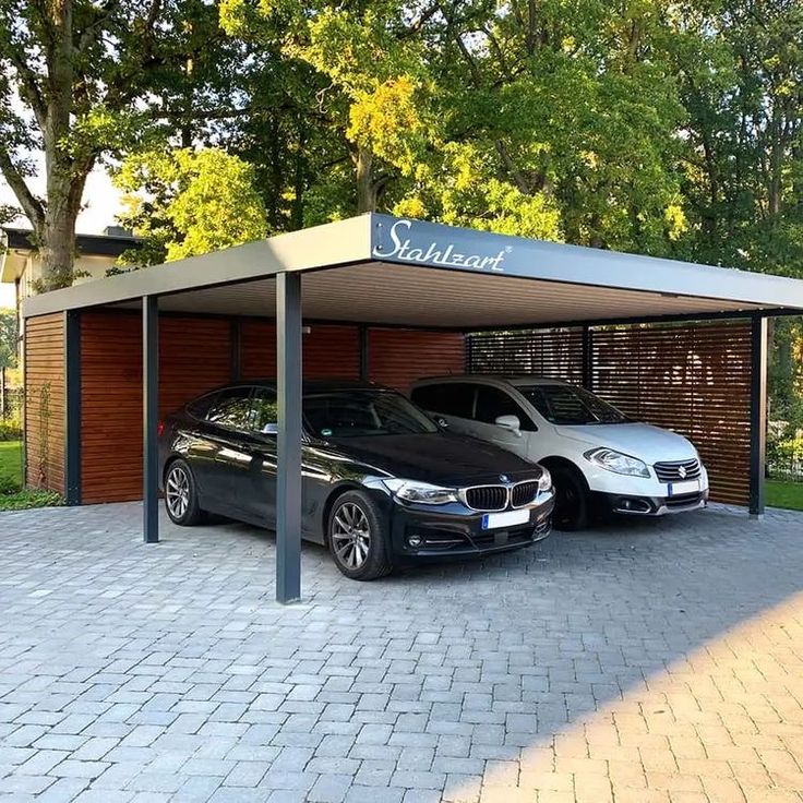 two cars parked in a parking lot next to each other on a brick walkway near trees