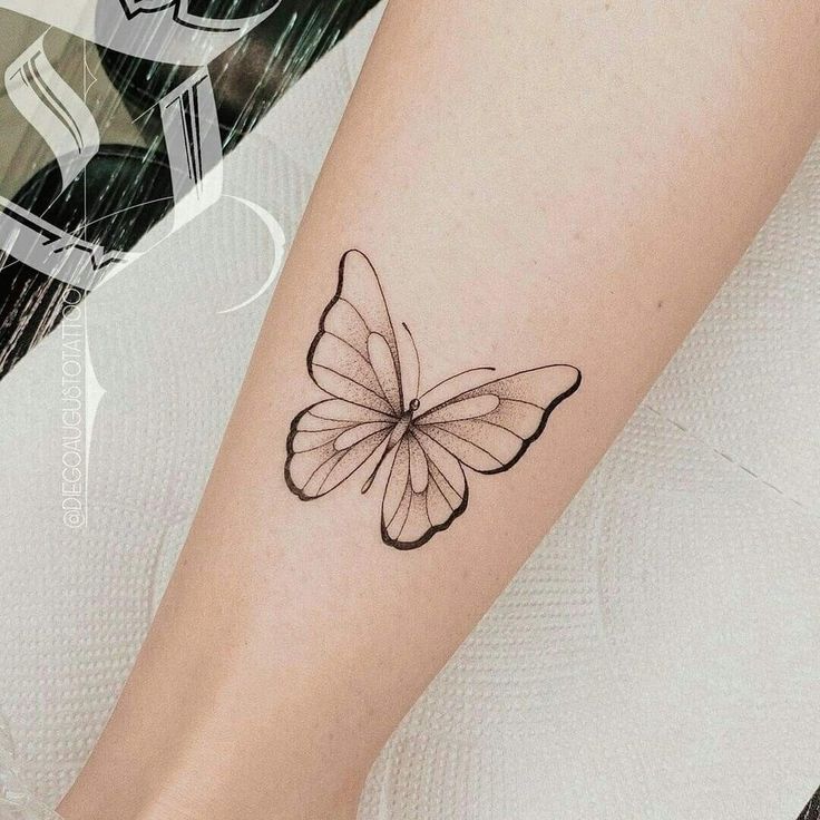 a small butterfly tattoo on the right forearm and leg, with black ink in it