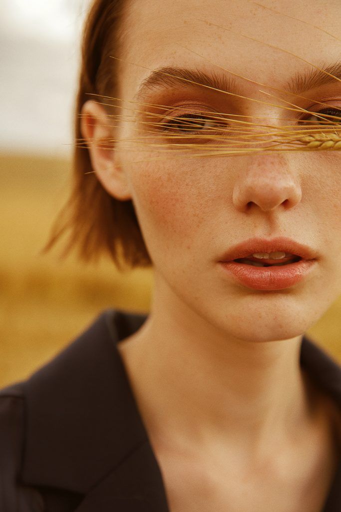 a woman with her eyes closed and hair blowing in the wind, wearing a black shirt