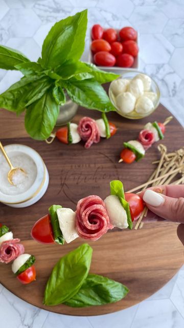 a wooden platter topped with meat and veggies on top of a table