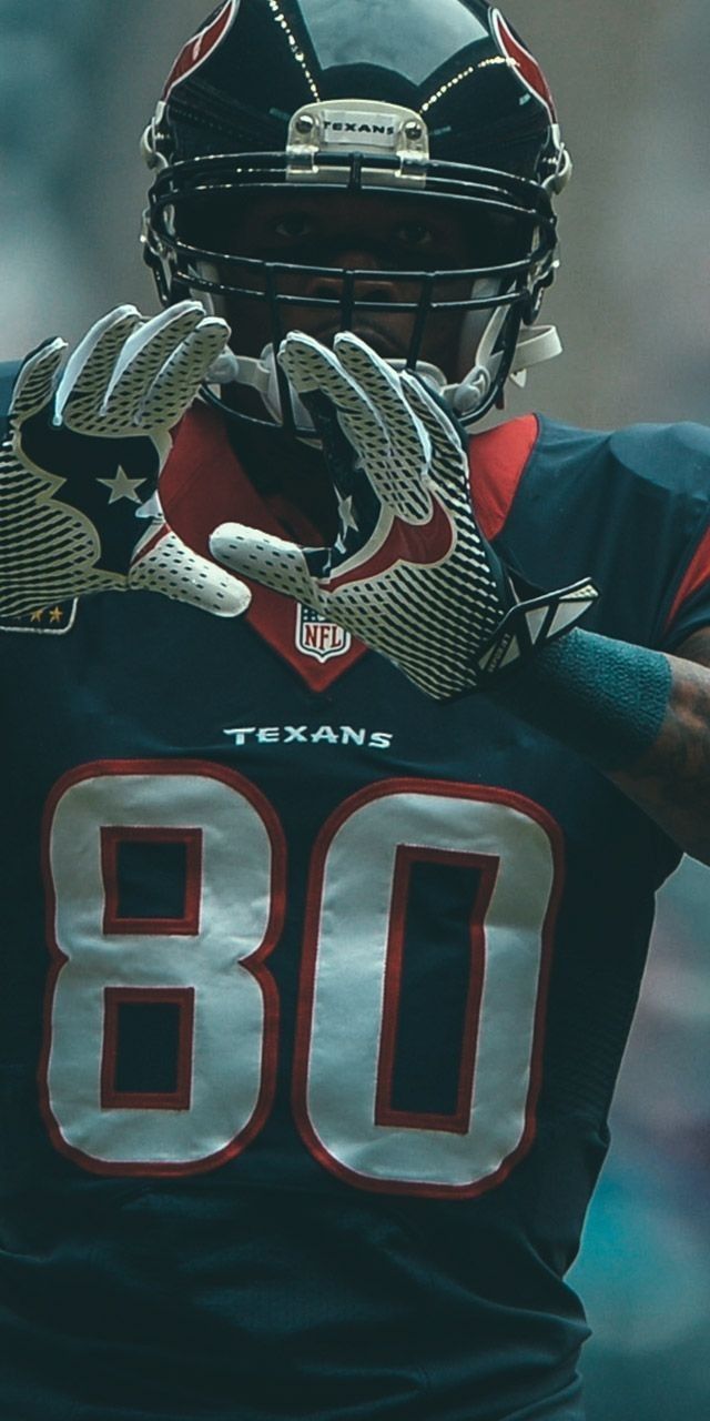 a close up of a person wearing a football uniform and holding his hands in the air