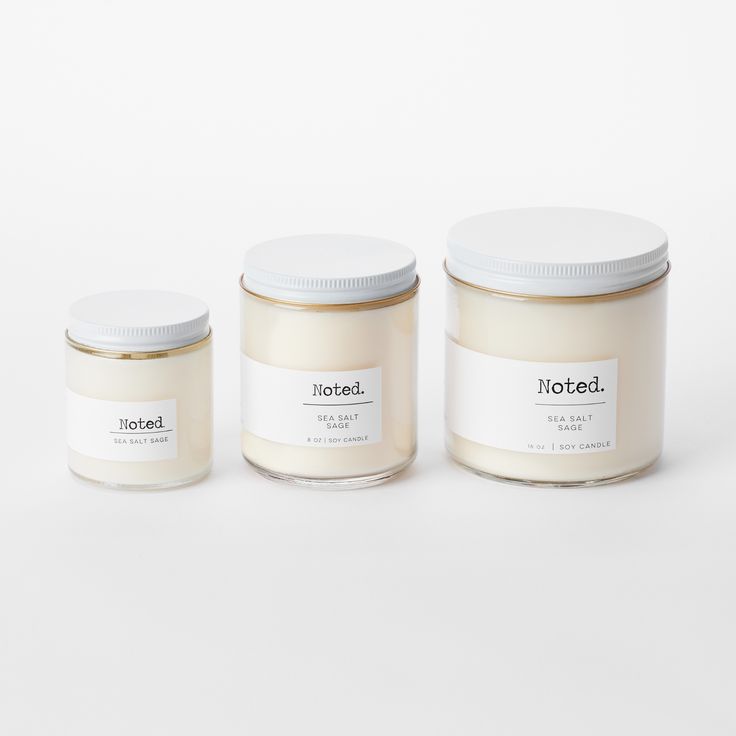 three jars with labels sitting next to each other on a white surface, one is empty and the other two are closed