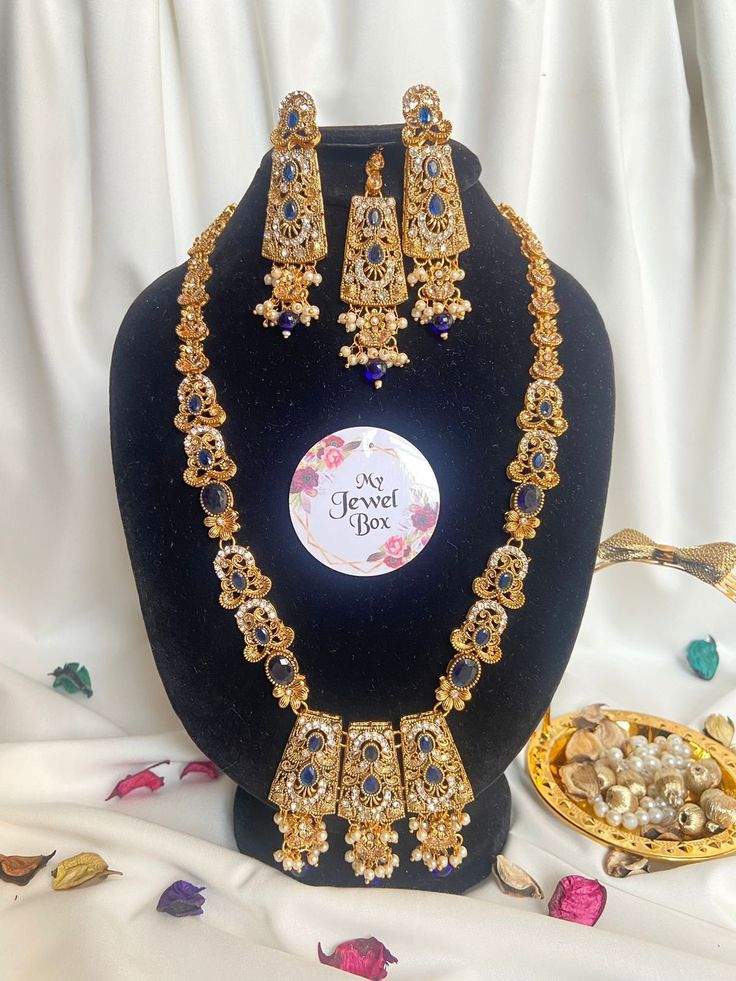 Add some sparkle to your special occasions with this stunning Indian/Pakistani Bridalwear Partywear Jewellery set from My Jewel Box. The set includes a Polki Zircon Long Dholna Mala Ranihaar, matching earrings and a tikka. The beautiful zircon gemstones are set in alloy metal and the set is made in Pakistan. It's perfect for engagements, weddings, anniversaries, birthdays, and Valentine's Day. The set features multiple natural gemstones with excellent cut grade and is perfect for those who love Bollywood Style Meenakari Sets For Eid, Festive Heavy Traditional Drape Sets, Festive Sets With Traditional Drape, Kundan Sets For Eid Celebration, Eid Celebration Kundan Sets, Semi-stitched Gold Anarkali Set With Meenakari, Gold Sharara With Meenakari For Eid, Eid Celebration Stone Work Tikka, Eid Festive Traditional Wear With Stone Work