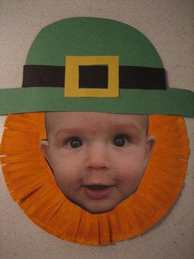 a child wearing a green hat and orange ribbon around his head with a yellow square in the center