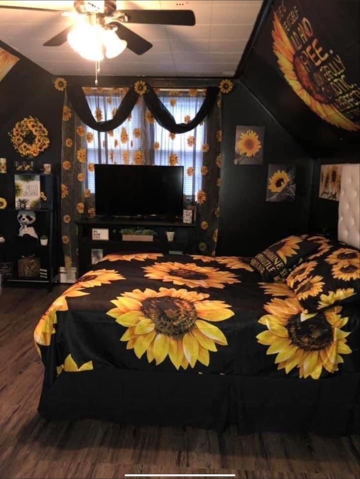 a bedroom with sunflowers on the bedspread and ceiling fan in it