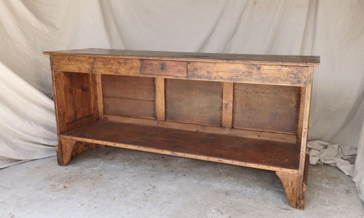 an old wooden table with two drawers on one side and a shelf on the other