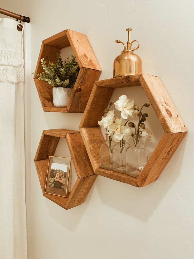 three wooden hexagonal shelves holding vases and flowers