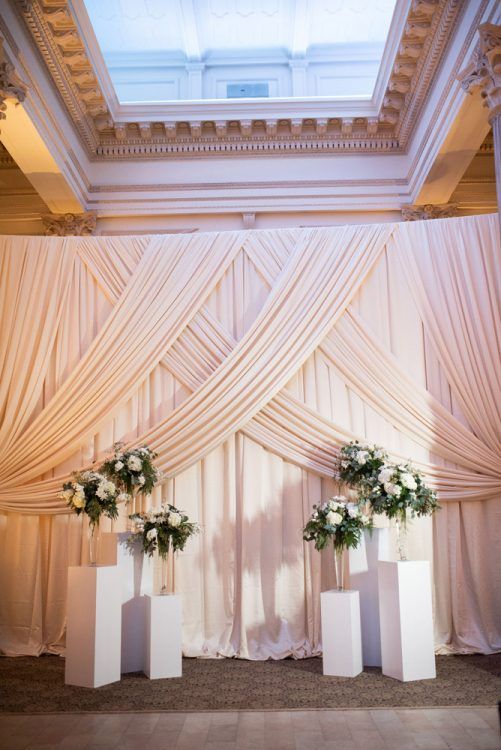 two tall vases with flowers are on the stage