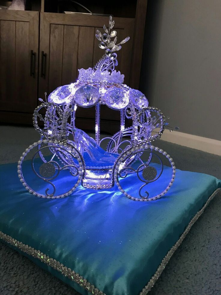 a blue cushion with a crystal carriage on it's back and lights in the middle