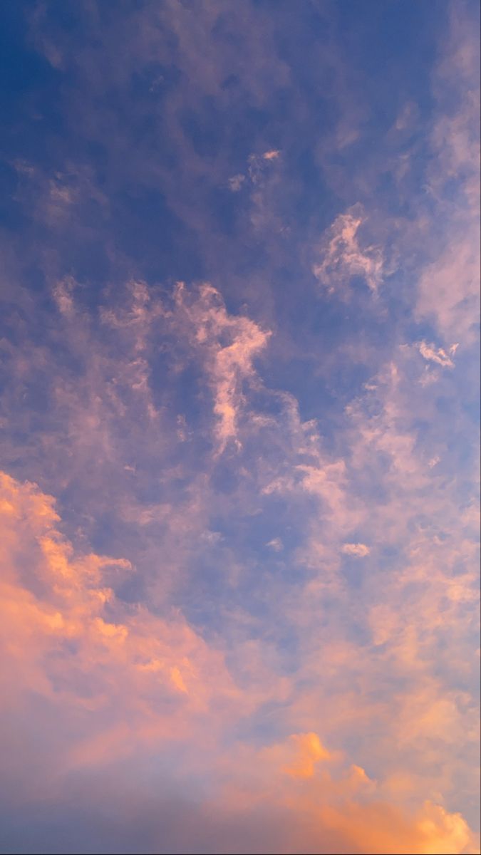 an airplane is flying high in the sky at sunset or dawn with some clouds above it