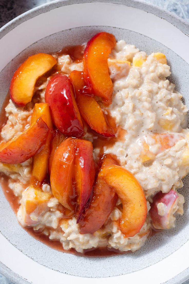 a bowl filled with oatmeal and sliced peaches