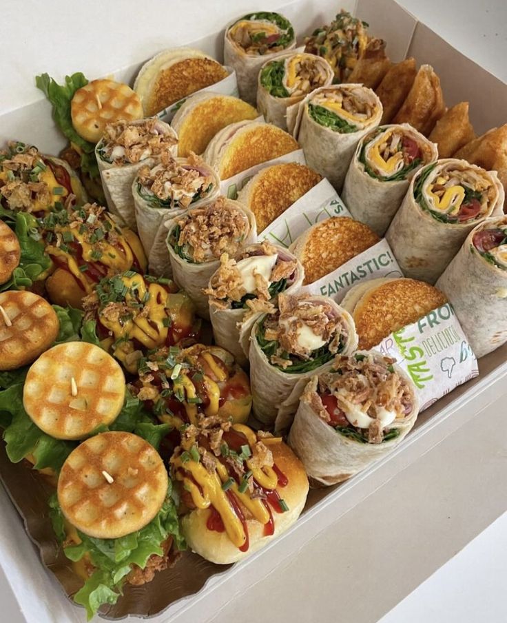 a box filled with lots of different types of sandwiches and waffles next to each other