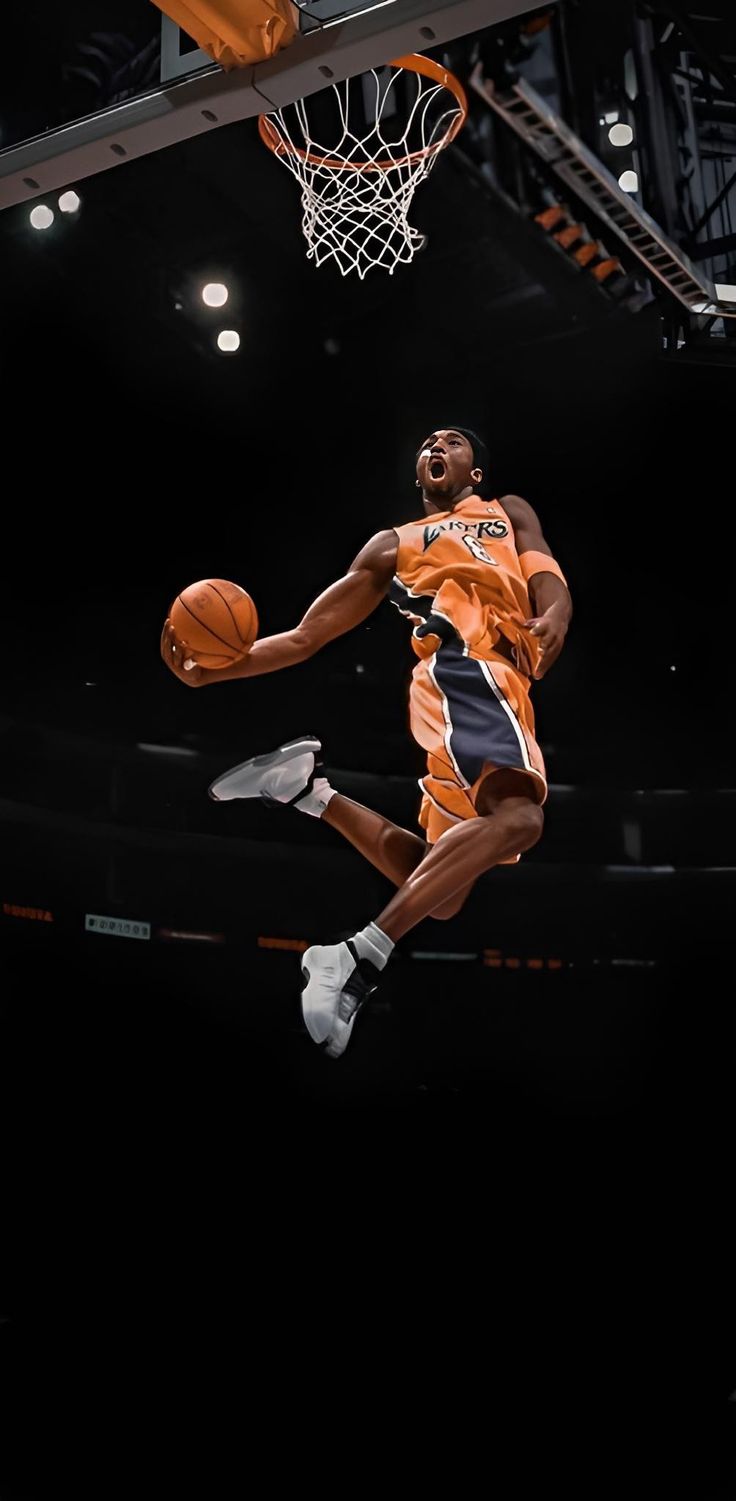 a basketball player jumping up into the air with a ball in his hand and an orange jersey on