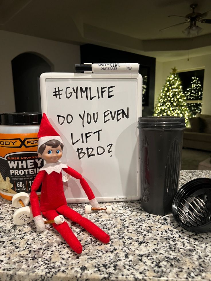 an elf is sitting next to a sign that says gym life do you even lift bob?