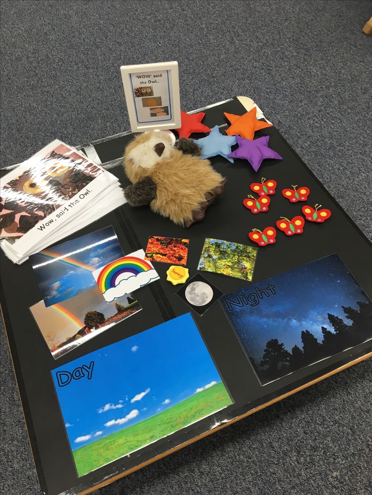 a stuffed animal sitting on top of a black table covered in pictures and magnets