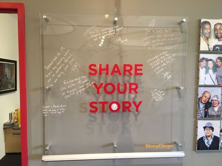 a glass sign that says share your story with pictures on the wall in front of it