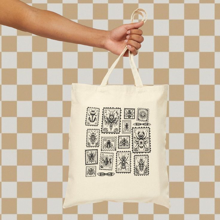 This 100% cotton bag is perfect for everyday wear. The bag features 20" handles (made from the same canvas) and features a bugs inside of stamps on one side of the bag.   15" x 16" Handle length, in 20.00 Screen Print Cotton Bag For Gift, Cotton Screen Print Bag As Gift, Cotton Screen Print Bag Gift, Hand Printed Cotton Bag For Gift, Eco-friendly Screen Print Bag For Daily Use, Eco-friendly Screen Print Bags For Daily Use, White Hand Printed Bags As Gifts, White Hand Printed Bag For Gift, White Hand Printed Bags For Gifts