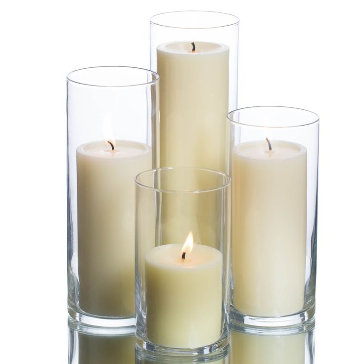 three tall candles are sitting next to each other in glass vases on a white background