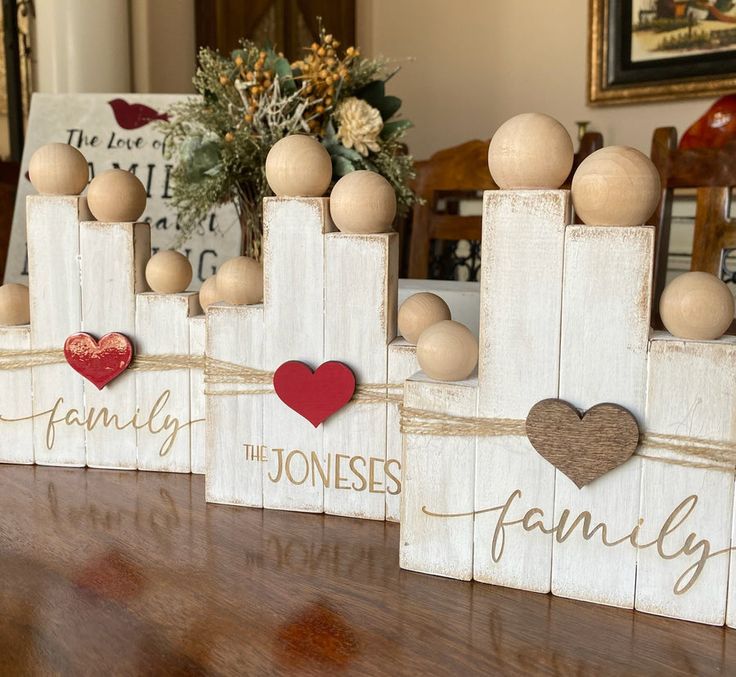 three wooden blocks with hearts on them and the words family are placed in front of each other