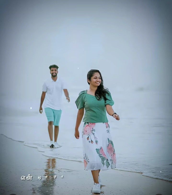 a man and woman walking on the beach