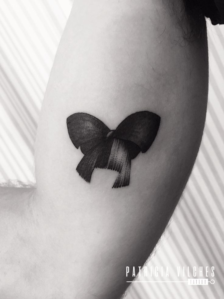 a black and white photo of a bow tattoo