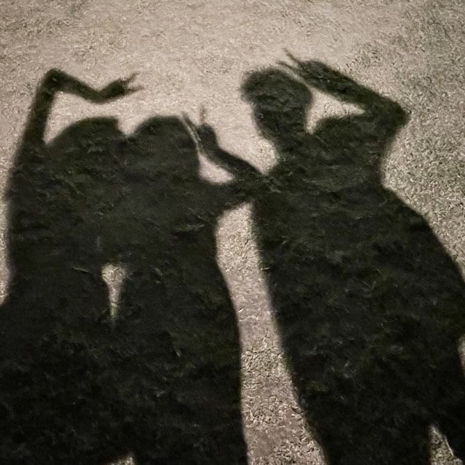 the shadow of two people standing next to each other