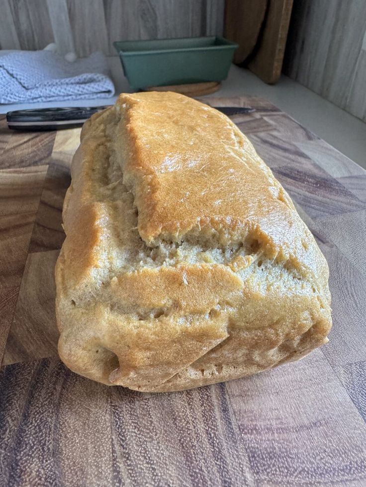 a loaf of bread sitting on top of a wooden cutting board