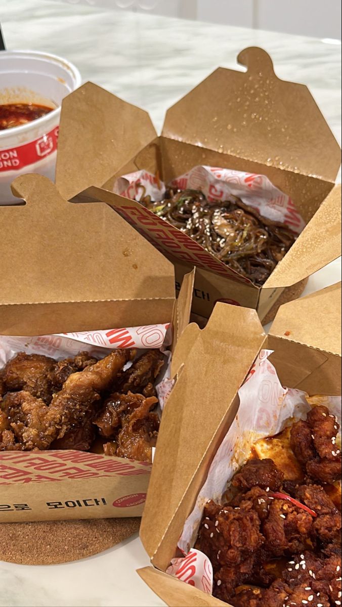 three boxes filled with food sitting on top of a table next to a bowl of soup