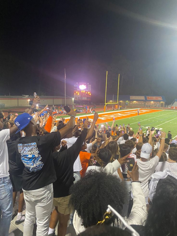 a group of people standing on top of a football field