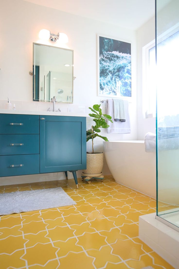 a bathroom with blue cabinets and yellow flooring