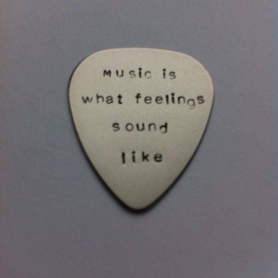 a white guitar pick with the words music is what feelings sound like