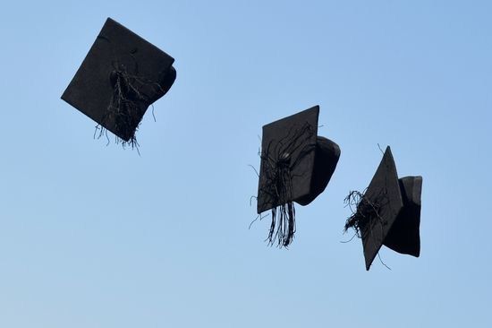 three graduation caps are flying in the air with tassels attached to their caps