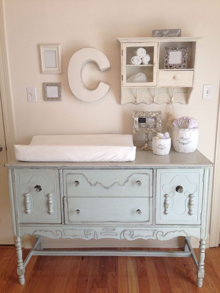 a baby's crib in the corner of a room next to a dresser