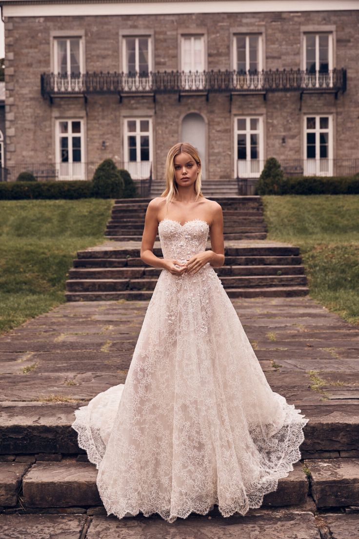 a woman in a wedding dress standing on some steps