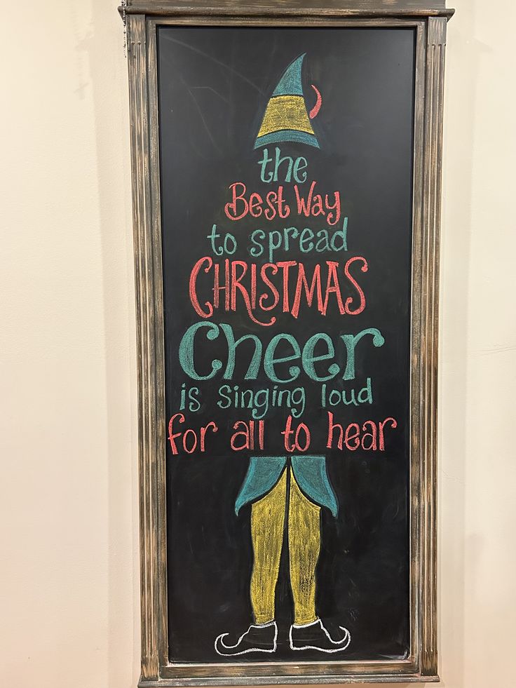 a chalkboard sign that says the best way to spread christmas cheer is singing loud for all to hear