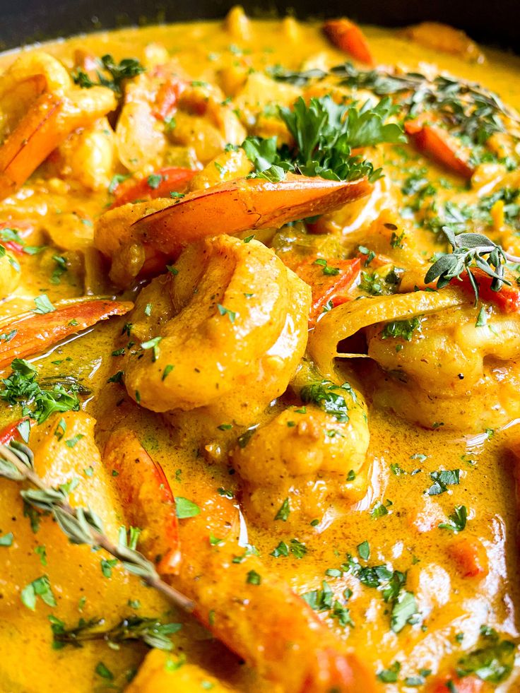 a close up of a bowl of food with shrimp and carrots