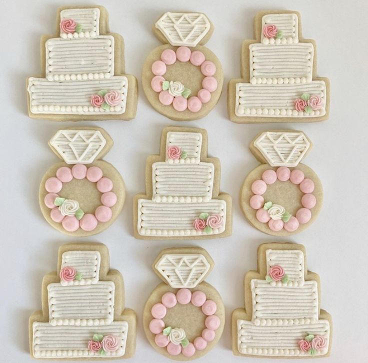 decorated cookies arranged in the shape of wedding cakes and groom's cake with pink flowers