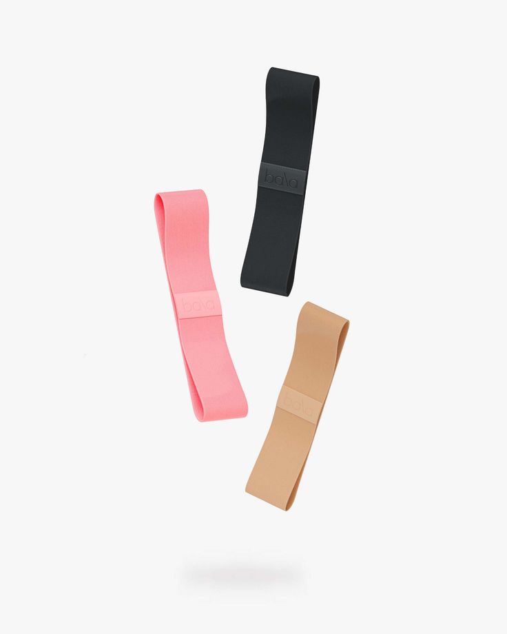 three different types of hair ties on a white background, one pink and one black