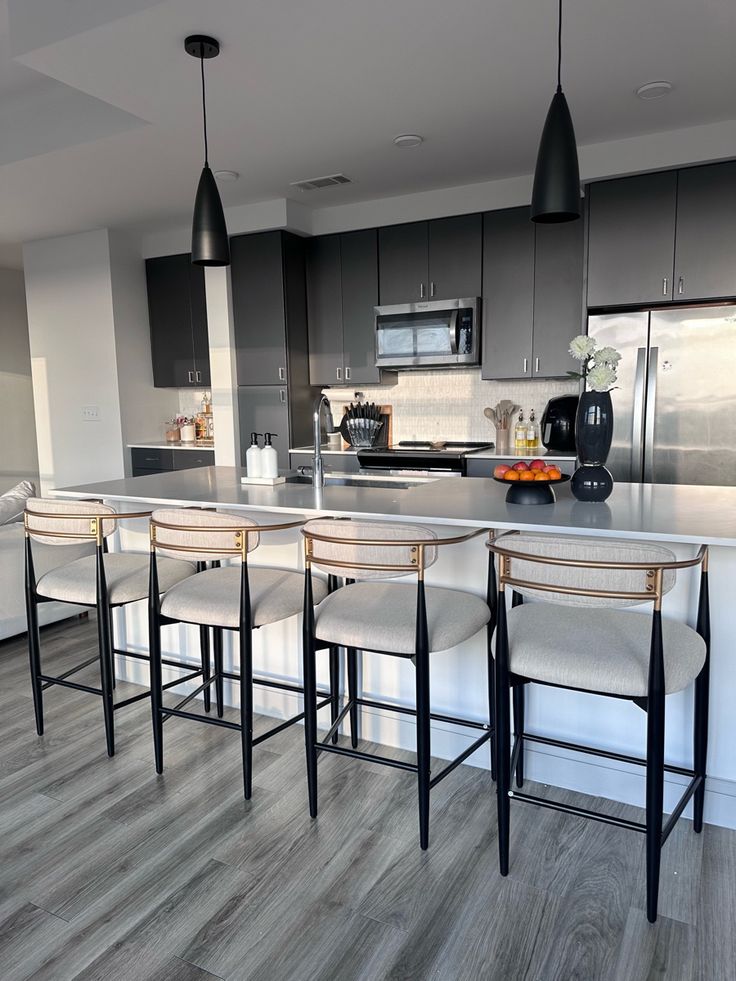 a kitchen with grey cabinets and white counter tops