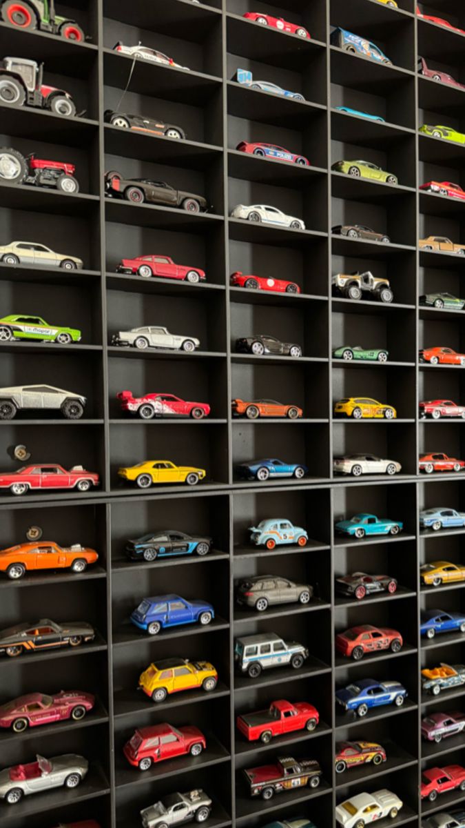 a room filled with lots of different types of toy cars on shelves next to each other