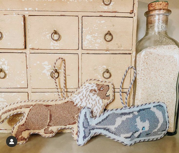 an old bottle with a dog on it next to a needled animal ornament