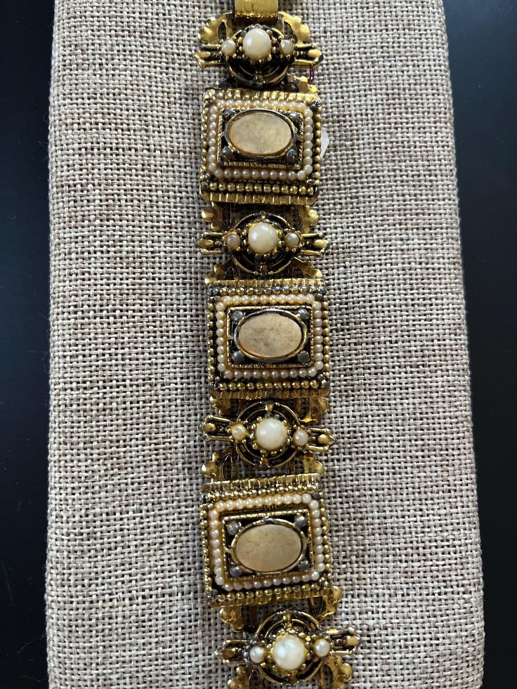 Pretty detailed bracelet from the 1960s  with gold metal and faux pearls. Dimensions are 6" L x 1"W. Victorian Gold-tone Jewelry For Formal Occasions, Elegant Bronze Bracelets For Wedding, Vintage Jeweled Gold Bracelets, Vintage Gold Jeweled Bracelets, Vintage Brass Gold Bracelet For Wedding, Elegant Antique Gold Brass Cuff Bracelet, Elegant Antique Gold Metal Bracelets, Elegant Antique Gold Metal Bracelet, Metal Costume Jewelry Bracelets With Jewels