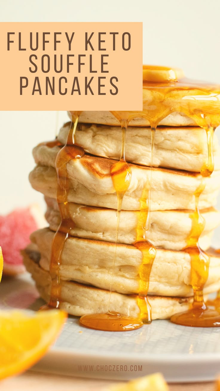 stack of fluffy keto pancakes with syrup drizzled over them and sliced oranges